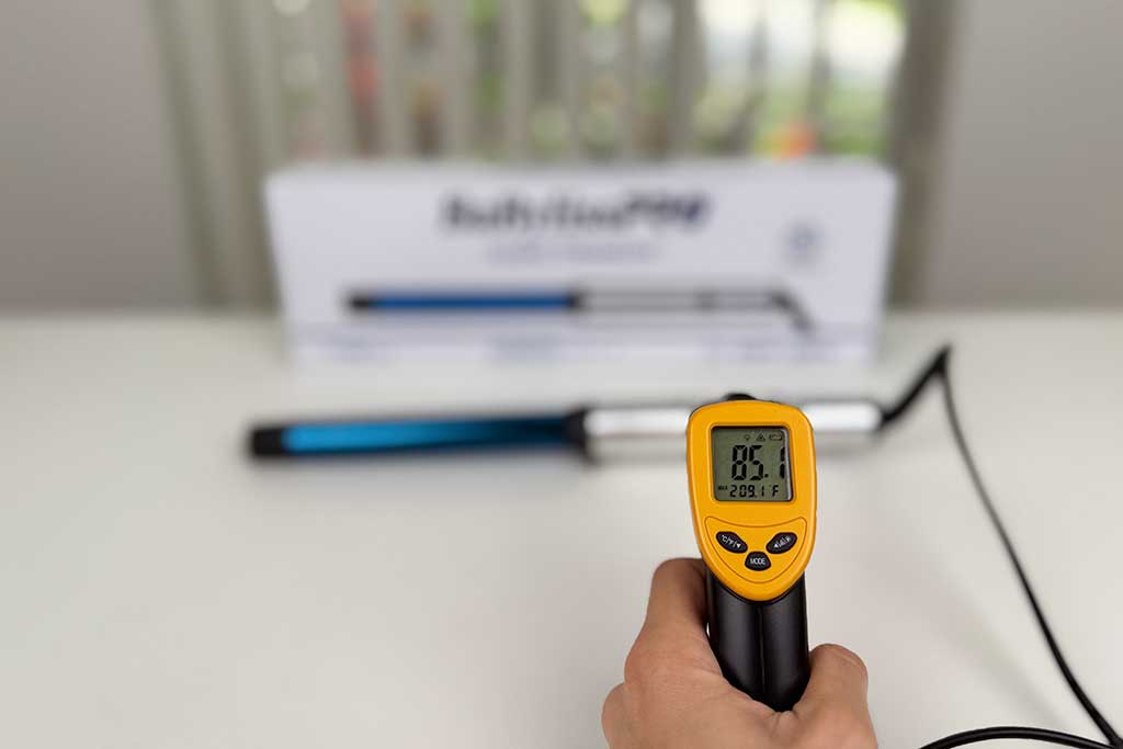 Infrared thermometer measuring 85°F on the handle of the BaBylissPRO Nano Titanium Curling Wand.