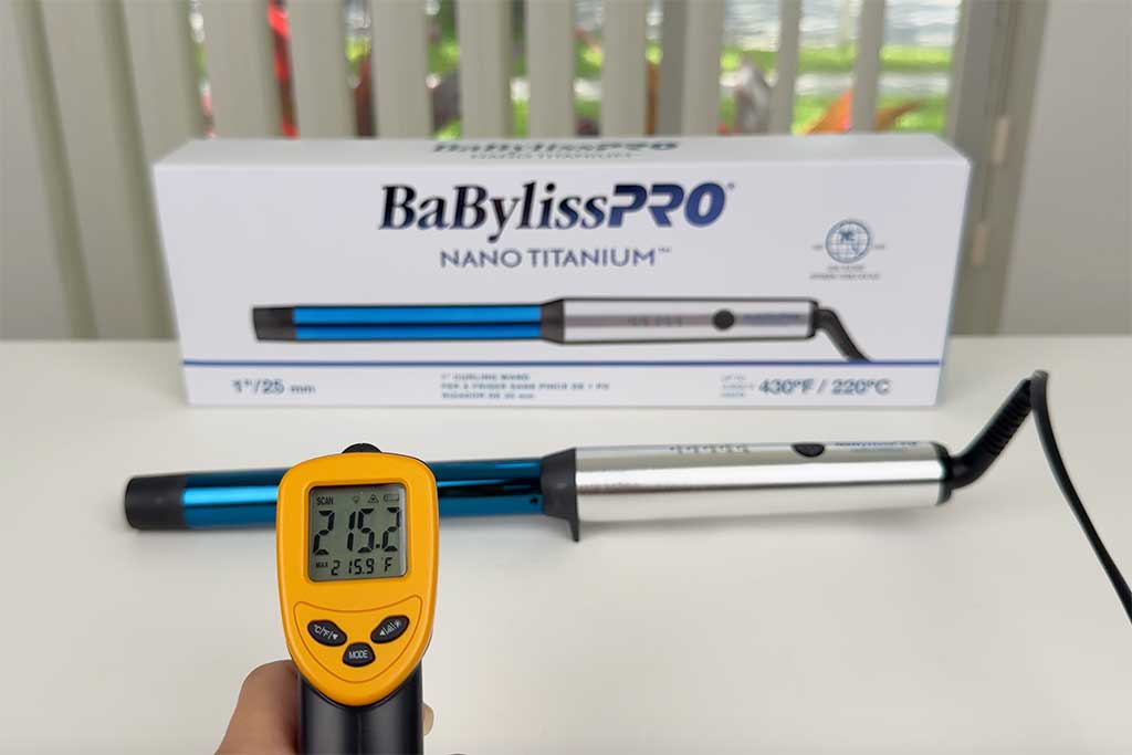 Infrared thermometer pointed at the BaBylissPRO Nano Titanium Curling Wand barrel surface.