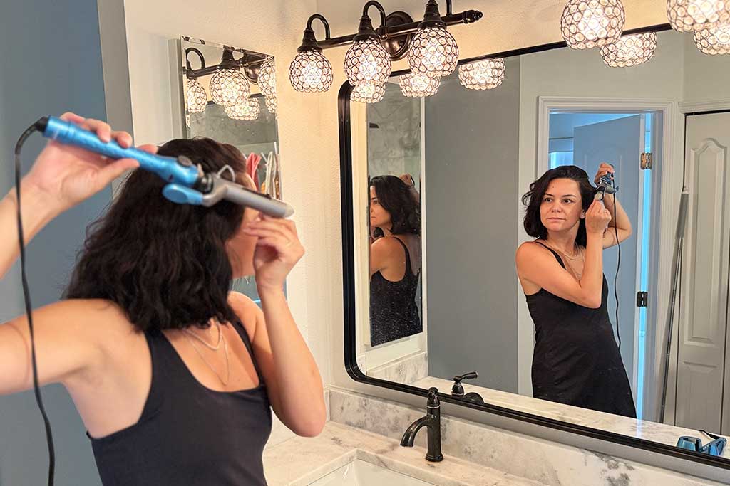 Woman with mid-length thick hair styling with the BaBylissPRO Nano Titanium Spring Curling Iron.