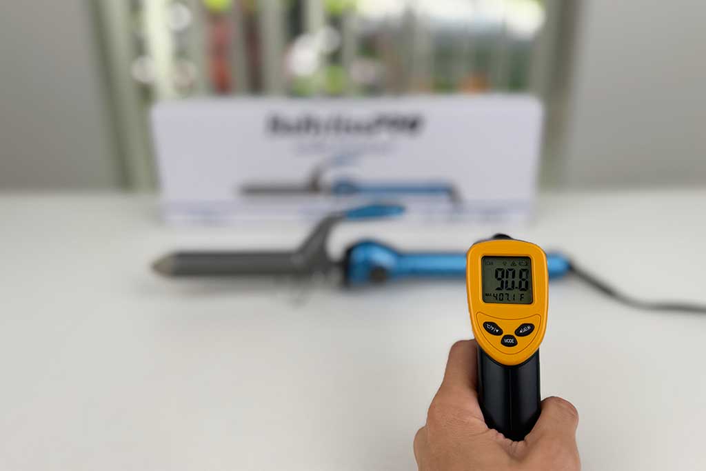 Infrared thermometer showing 90°F on the handle of the BaBylissPRO Nano Titanium Spring Curling Iron.