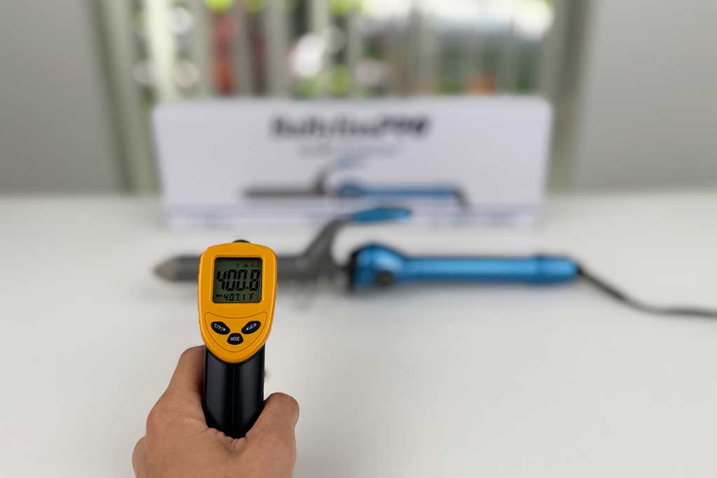 Infrared thermometer showing ~400°F on the barrel surface of the BaBylissPRO Nano Titanium Spring Curling Iron.