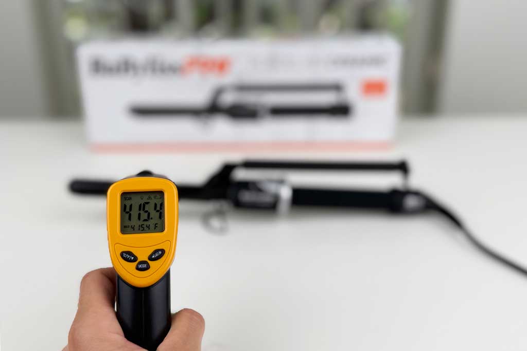 Infrared thermometer reading 415°F on the BaBylissPRO Marcel Curling Iron barrel surface.