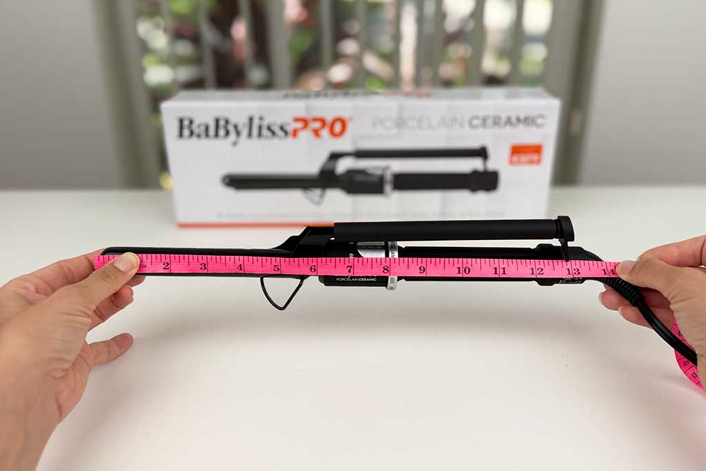 Measuring tape showing 13.5-inch total length of the BaBylissPRO Porcelain Ceramic Marcel Curling Iron.