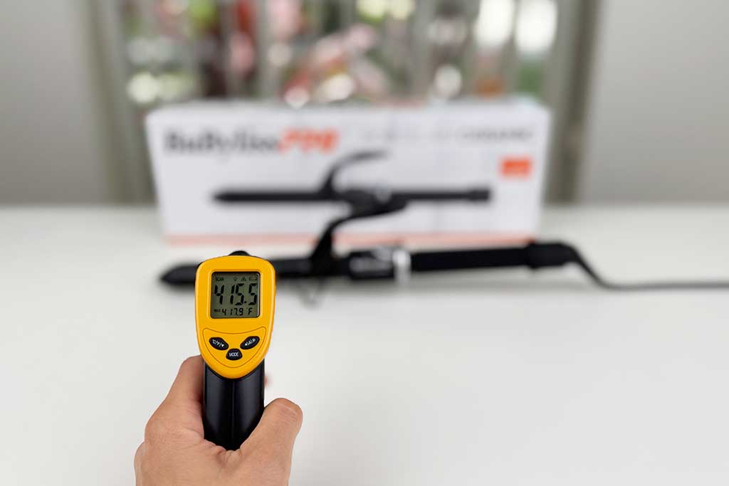 Infrared thermometer reading 415°F on the BaBylissPRO Porcelain Ceramic Spring Curling Iron barrel surface.