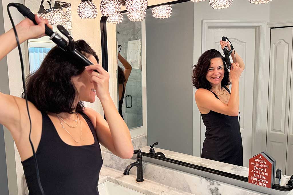 Woman styling mid-length hair with the BaBylissPRO Porcelain Ceramic Spring Curling Iron.