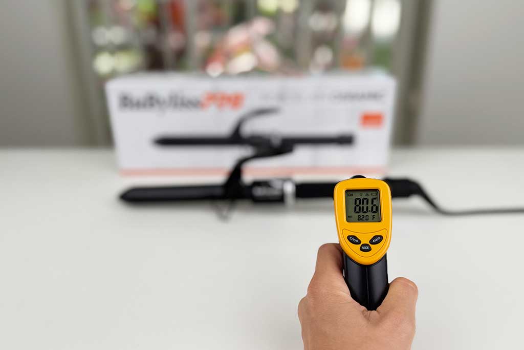 Infrared thermometer showing 80°F on the handle of the BaBylissPRO Porcelain Ceramic Spring Curling Iron.