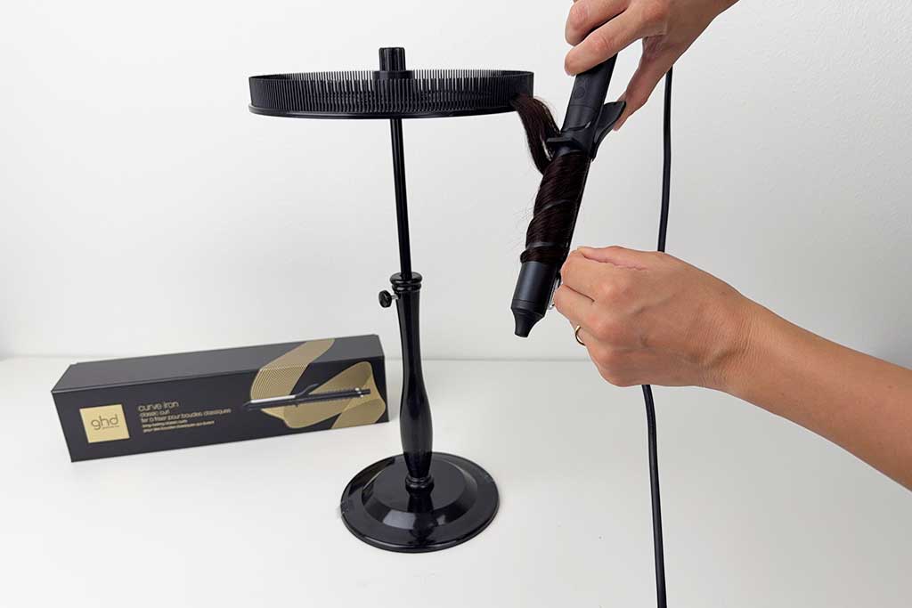 Human hair wig section being wrapped around the barrel of the GHD Classic Curl Curling Iron during testing.