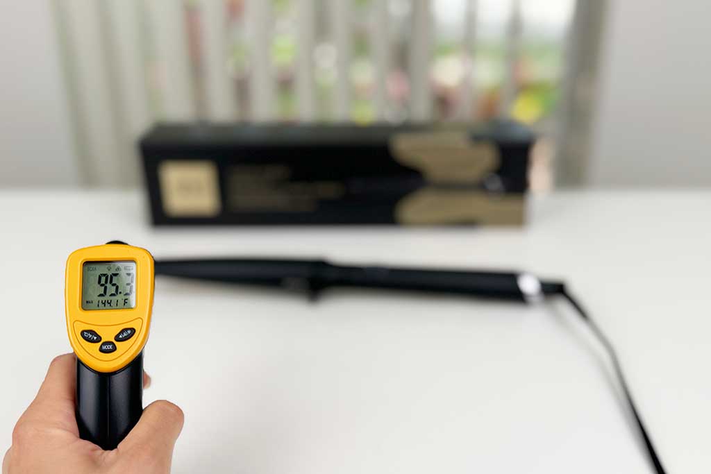 Digital caliper measuring the 1-inch cool tip of the GHD Creative Curl Wand, with infrared thermometer reading 95°F.