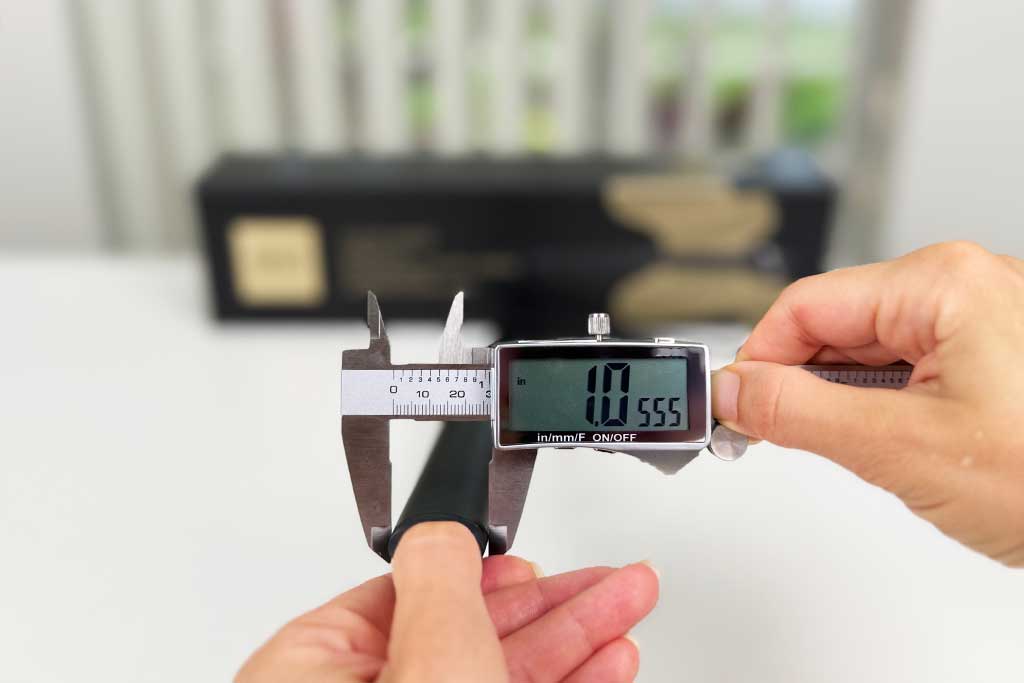 Digital caliper measuring the tapered ceramic barrel of the GHD Creative Curl Wand, showing 1.2 inches at the base and 1 inch at the tip.