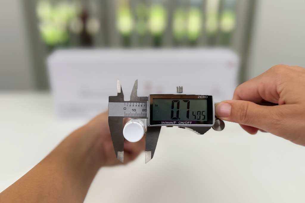 Close-up of the T3 SinglePass Wave curling wand tip being measured with a caliper, showing 0.75 inches at the narrow end.