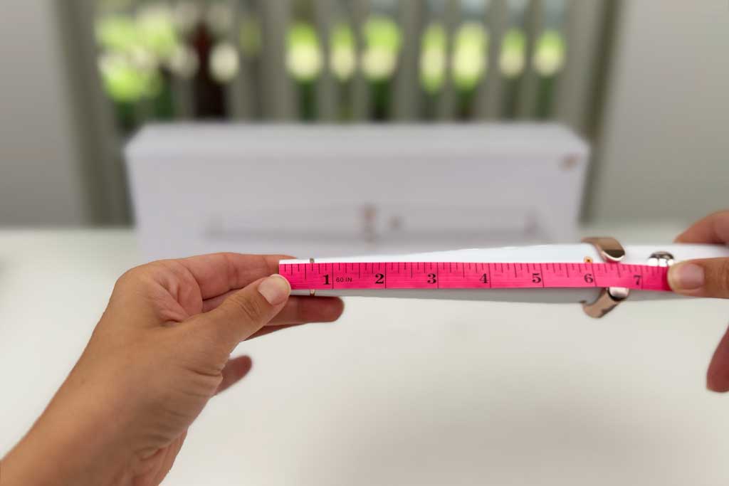 Digital caliper measuring the 0.75-inch cool tip of the T3 SinglePass Wave curling wand, which reached 170°F in heat tests.