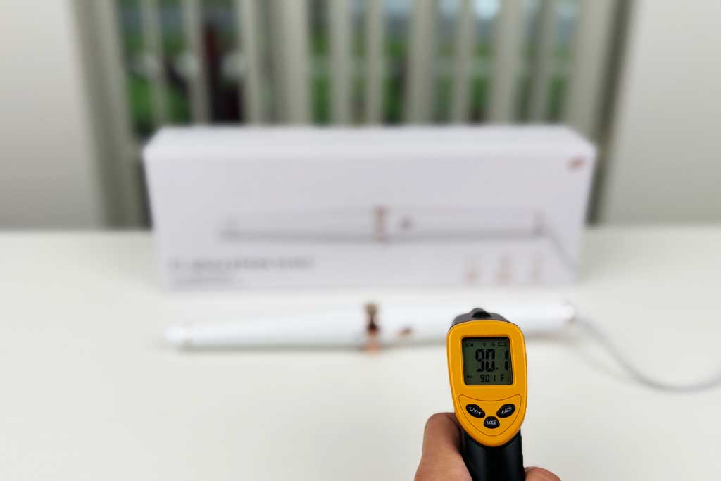 Infrared thermometer displaying 90°F aimed at the handle of the T3 SinglePass Wave curling wand during lab testing.