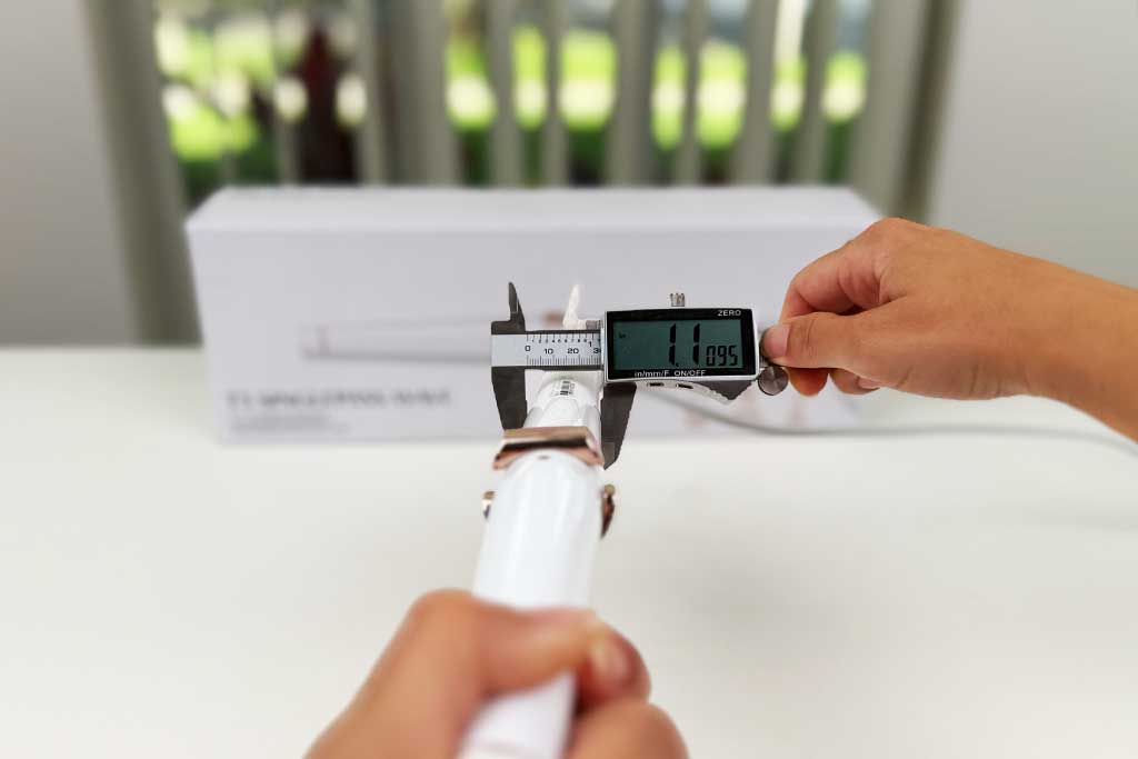 Digital caliper measuring the 1.11-inch handle width of the T3 SinglePass Wave curling wand.