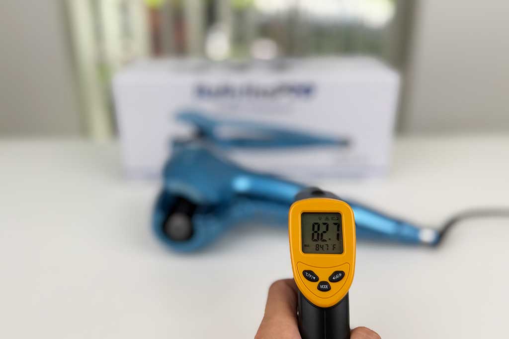Infrared thermometer pointed at MiraCurl 3 handle during testing.