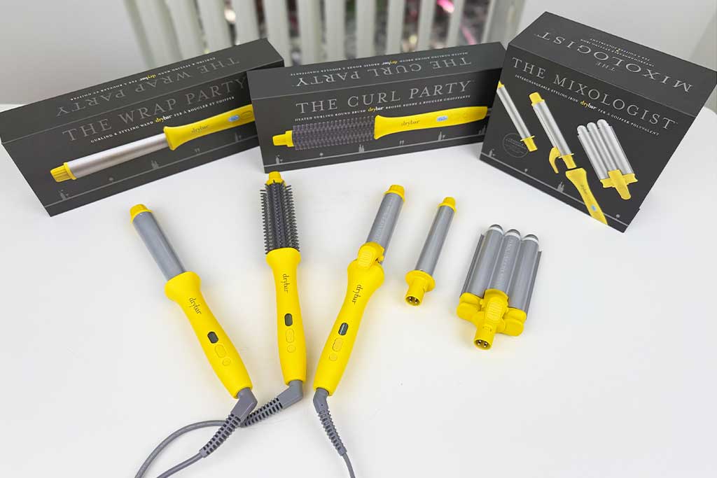 Three Drybar curling tools (Wrap Party, Mixologist, Curl Party) arranged on a lab bench for comparison.