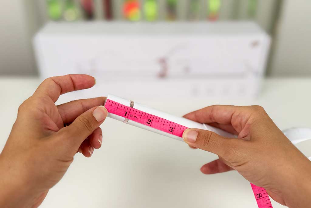 Digital caliper measuring the 1.2-inch cool tip of the T3 CurlWrap curling iron, safe for guiding wraps but reached 170°F in heat tests.