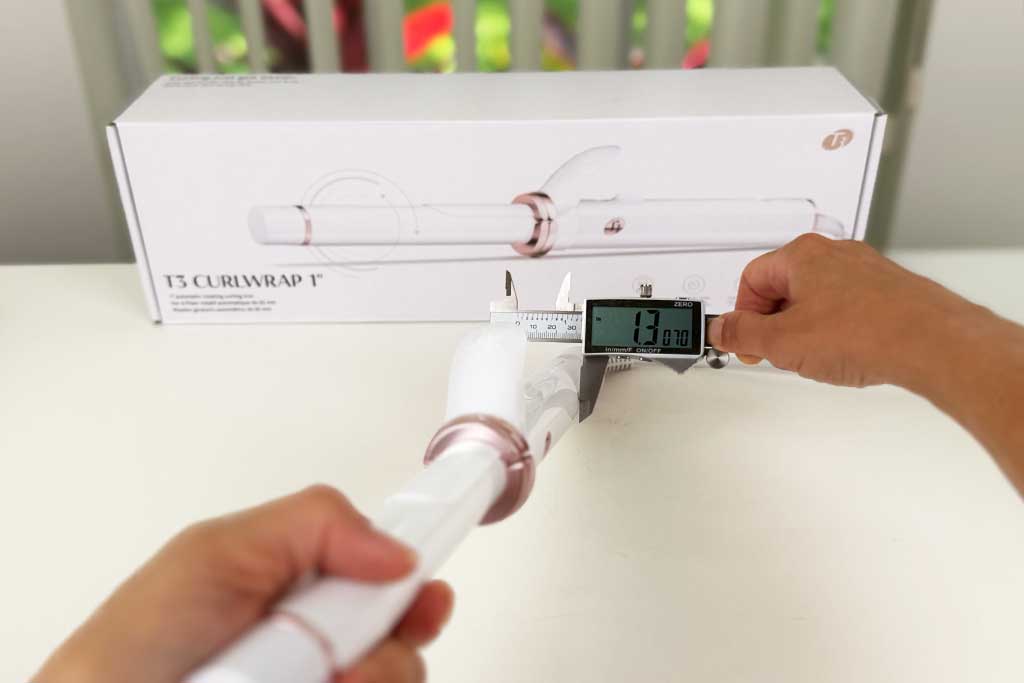 Digital caliper measuring the 1.3-inch handle width of the T3 CurlWrap curling iron.