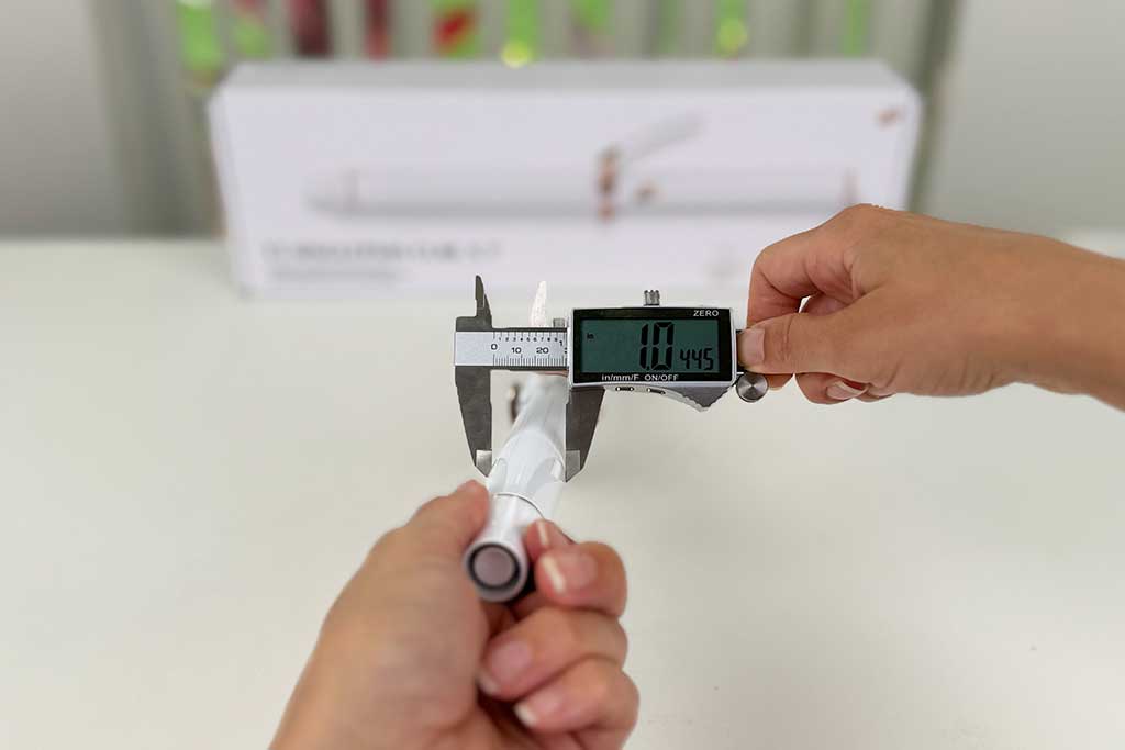 Digital caliper measuring the 1-inch ceramic barrel width of the T3 SinglePass Curl X curling iron.