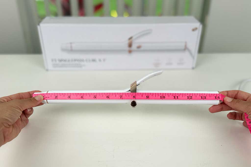 Measuring tape stretched alongside the T3 SinglePass Curl X curling iron showing 14.5 inches total length.