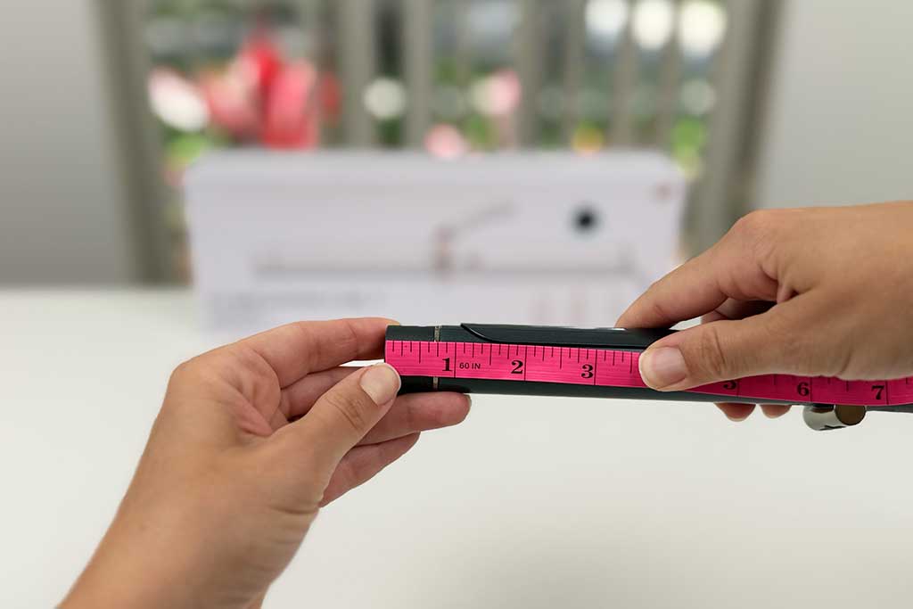 Infrared thermometer reading 230°F pointed at the cool tip of the T3 SinglePass Curl curling iron.