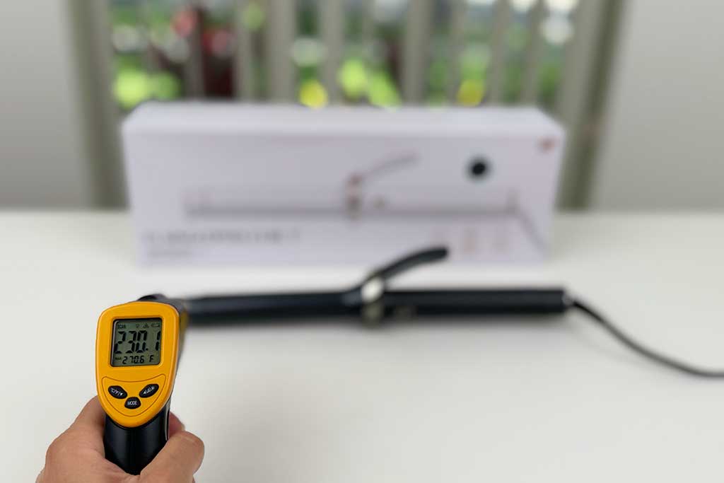 Infrared thermometer showing 230°F aimed at the cool tip of the T3 SinglePass Curl curling iron.