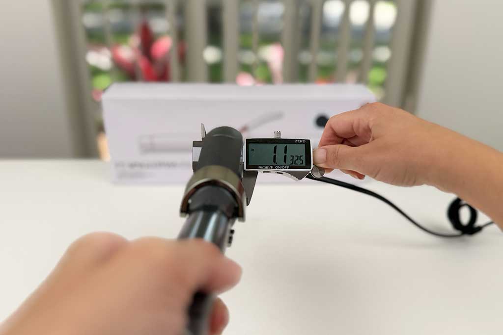 Digital caliper showing 1.1 inches while measuring the handle of the T3 SinglePass Curl curling iron.